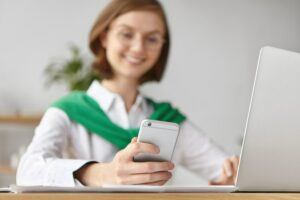 femme souriante qui regarde sa carte de fidélité sur son wallet mobile